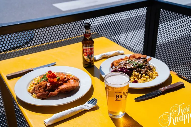 Patio table set with plates and a cold beer